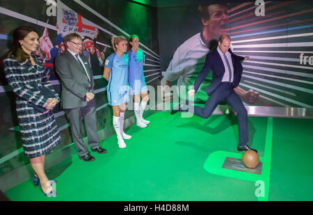 La Duchessa di Cambridge (sinistra) guarda come il Duca di Cambridge prende uno spot-kick in un computer-generato penalità shoot-out gioco durante la loro visita al Museo Nazionale del Calcio in Manchester. Foto Stock