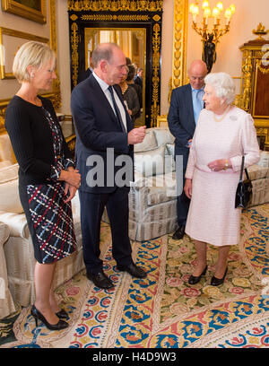 Queen Elizabeth II incontra Sir Roger de Haan e Lady de Haan, all'inaugurazione di un ritratto della sua dall artista britannico Henry Ward, segnando sei decenni di patrocinio alla Croce Rossa Britannica, che è stato presentato al Castello di Windsor in Berkshire. Foto Stock