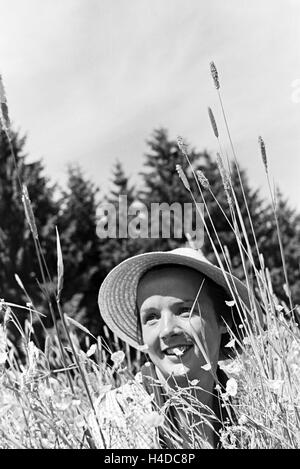 Porträt einer jungen Frau in einer Blumenwiese, Freudenstadt, Deutschland 1930er Jahre. Ritratto di una giovane donna in un campo di fiori, Freudenstadt Germania 1930s. Foto Stock