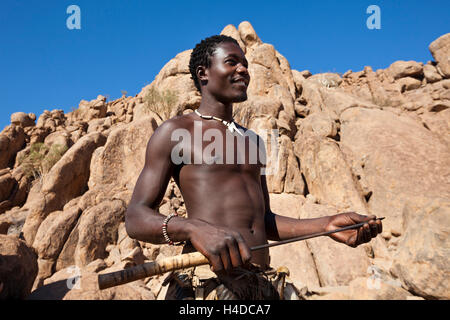 Il cacciatore africano dal popolo Damara rimane vicino alla baita di villaggio in Namibia, Sud Africa Foto Stock