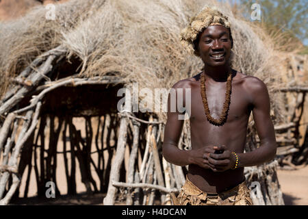 Il cacciatore africano dal popolo Damara rimane vicino alla baita di villaggio in Namibia, Sud Africa Foto Stock