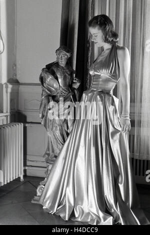 Ein modello bei der Anprobe eines Kleides der Berliner Modeschöpferin Hilda Romatzki, Deutschland ca. 1939. Un modello cercando un abito del designer di moda Hilda Romatzki, Germania ca. 1939. Foto Stock