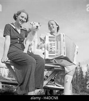 Zwei junge Frauen Mit einem Akkordeon, Deutschland 1930er Jahre. Due giovani donne con una fisarmonica Germania 1930s. Foto Stock