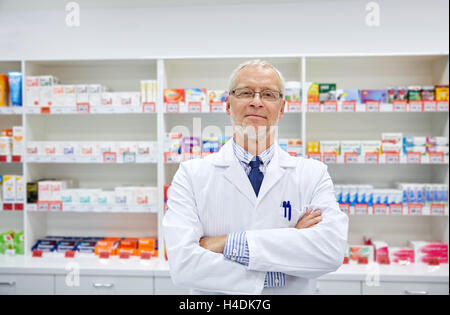 Senior farmacista maschio in camice bianco in farmacia Foto Stock