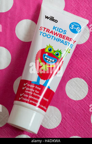 Tubo di Wilko kids dentifricio alla fragola per bambini di età compresa tra 3 e 6 a pois rosa sullo sfondo Foto Stock