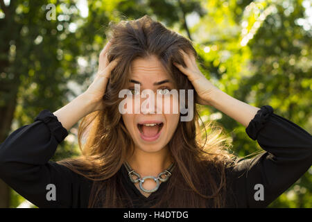 Donna che mantiene la sua caparbia capelli Foto Stock