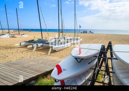 MORRO Jable Fuerteventura - Febbraio 7, 2014: tavole da surf e catamarano barche sulla spiaggia di Morro Jable. Si tratta di un popolare resort per vacanze sull isola di Fuerteventura. Foto Stock