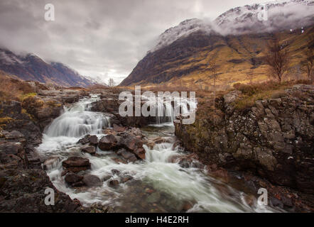 Fiume Coe cascata inferiore, Glencoe, con nuvole di fumo persistente su Aonach Eagach Ridge, Highlands, Scozia, neve montagne Foto Stock
