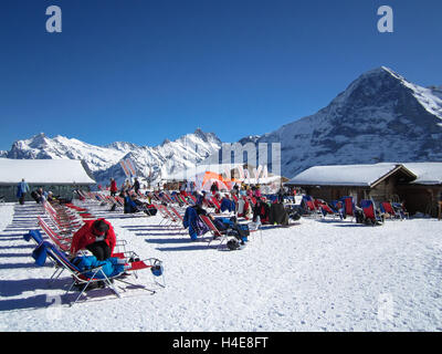 Persone rilassarsi e godersi il sole dopo lo sci su Männlichen, Jungraujoch area sciistica, Svizzera, Europa Foto Stock