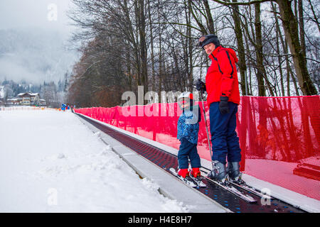 Padre insegnamento sci felice del suo piccolo figlio durante una vacanza invernale a Kitzbuhel,tirolese Alpi, Austria Foto Stock