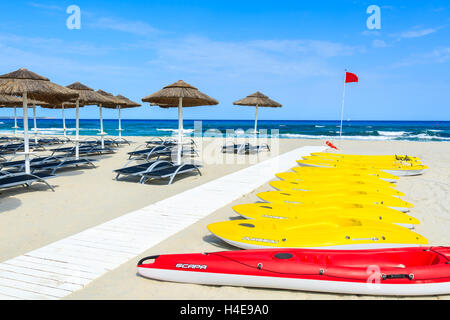 PORTO GIUNCO SPIAGGIA, SARDEGNA - 25 Maggio 2014: giallo kayak e ombrelloni con sedie a sdraio sul Porto Giunco spiaggia, l'isola di Sardegna, Italia. A sud dell'isola ha spiagge più belle in Europa. Foto Stock