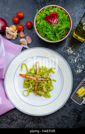 Italian pasta agli spinaci con organici aglio e pancetta e formaggio parmigiano Foto Stock