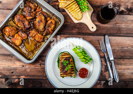 Sticky il pollo con la salsa piccante, panini tostati con a grana grossa sale e olio di oliva plus kebab di cetriolo Foto Stock