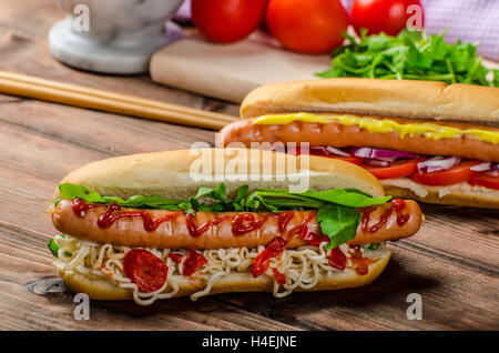 Variazione su red hot dogs, cipolla pomodoro, rucola e peperoncino piccante con spaghetti cinesi Foto Stock