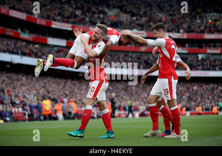 Dell'Arsenal Theo Walcott (sinistra) festeggia con i compagni di squadra Shkodran Mustafi (seconda a sinistra) e Granit Xhaka (destra) dopo il suo punteggio del team Seconda goalduring la Premier League a Emirates Stadium di Londra. Foto Stock