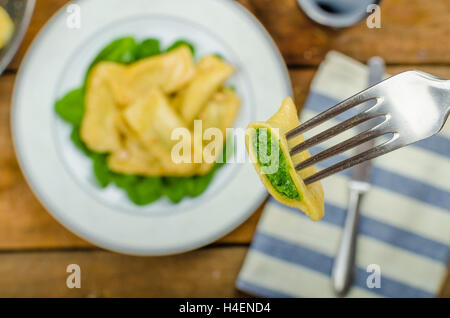 Ravioli fatti in casa ripieni di spinaci e ricotta fresca, melograno Foto Stock