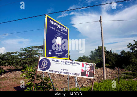 Segni raffiguranti cambogiano di partiti politici sono visualizzate vicino a una strada nel villaggio di Chork, Cambogia. Foto Stock