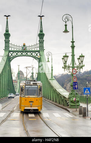 Tram giallo sul ponte della libertà o della libertà ponte in Budapest, Ungheria. Foto Stock
