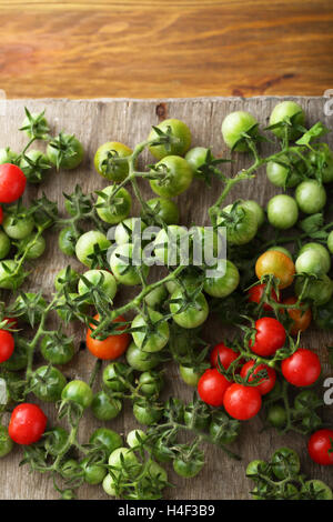 Rami di pomodori ciliegia su legno, prodotti alimentari al di sopra di Foto Stock