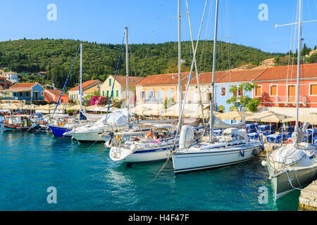 FISKARDO PORT, l'isola di Cefalonia, Grecia - Sep 19, 2014: Yacht barche sul blu del mare e la vista di Fiskardo villaggio di pescatori con la porta. Yachting è una delle attività più popolari su isole greche. Foto Stock