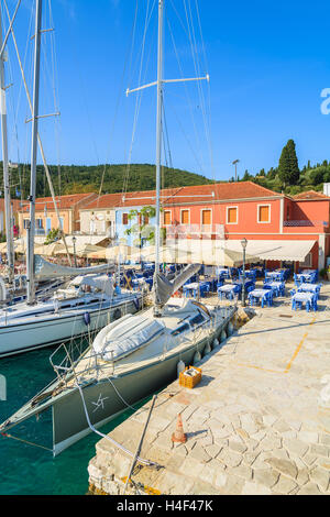 FISKARDO PORT, l'isola di Cefalonia, Grecia - Sep 19, 2014: Yacht barche sul blu del mare e la vista di Fiskardo villaggio di pescatori con la porta. Yachting è una delle attività più popolari su isole greche. Foto Stock