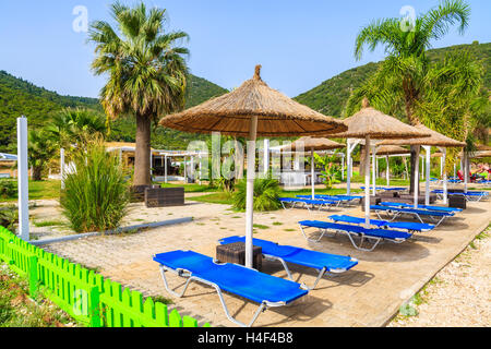 Lettini con ombrelloni sulla famosa spiaggia di Antisamos sull'isola di Cefalonia, Grecia Foto Stock