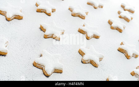 La cannella Star Cookies sul bianco neve di zucchero a velo Foto Stock