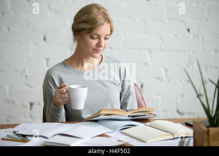 Ritratto di studente ragazza alla scrivania con la tazza in mano Foto Stock