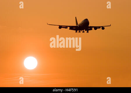 Silhouette di un Boeing 747-400 sull approccio a Londra Heathrow al tramonto. Foto Stock