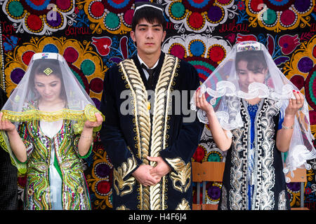 I giovani mostrano la tradizionale cerimonia di matrimonio in Tagikistan durante la celebrazione Nowruz al centro della città di Khujand Foto Stock