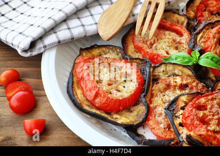 Gustoso pasto del Ringraziamento, melanzane arrosto con pomodoro e formaggio sulla piastra su un tavolo di legno, delizioso cibo fatto in casa Foto Stock
