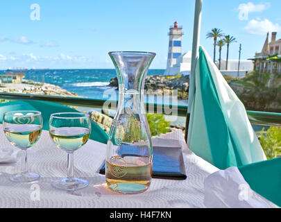 Il modo migliore per rilassarsi sull'Oceano Atlantico, la costa è di degustare il vino locale in un accogliente ristorante all'aperto in corrispondenza di una piccola baia Foto Stock