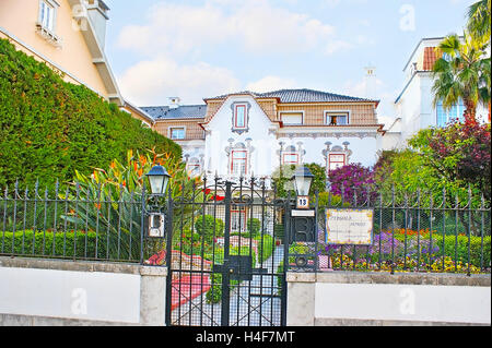 La bellissima villa, decorata con ornamenti tradizionali, è nascosto nel lussureggiante giardino Foto Stock