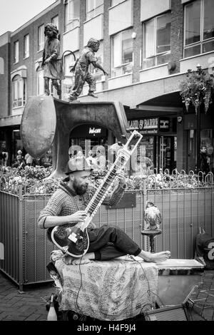 Buskers giocando un Grand Pro Tun Sitar un strumento indiano in Abington Street, centro di Northampton. Foto Stock