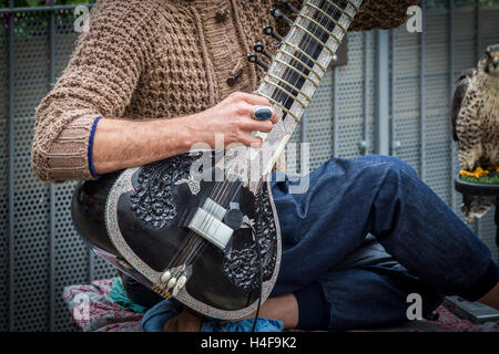 Buskers giocando un Grand Pro Tun Sitar un strumento indiano in Abington Street, centro di Northampton. Foto Stock