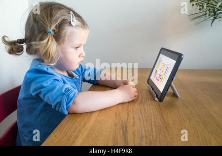 Due anni di bambino guardando i bambini di cartoon su Apple iPad, REGNO UNITO Foto Stock