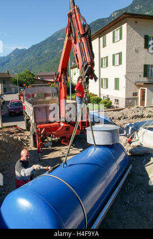 Biasca, Switzewrland - lavoratori mentre posa sul terreno di un serbatoio per gas a Biasca sulla parte italiana della Svizzera Foto Stock