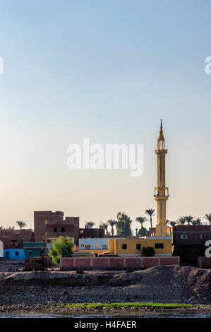 Una moschea domina lo skyline e nani vicino da case, sorge sulle rive del fiume Nilo vicino a Luxor. Foto Stock