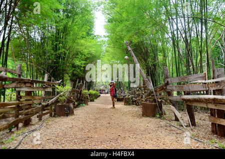 Tailandese donne viaggi e posa per ritratto sul marciapiede pietra schiacciata con bambù grotta a livello nazionale etnica Parco Culturale in Tad Foto Stock