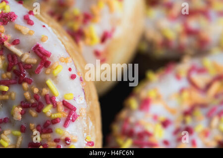 Una macro close up di quattro ciambelle glassate. Foto Stock