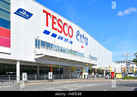 Inglese Tesco Extra store e 24 ore di shopping segni sopra di terra pavimento coperto cliente parcheggio auto per i grandi supermercati del Regno Unito nella città di Slough Berkshire REGNO UNITO Foto Stock