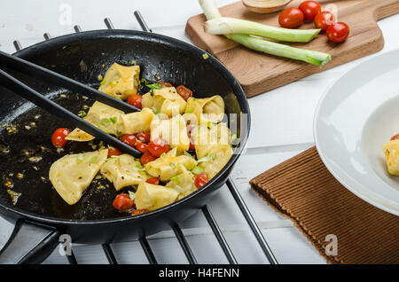 Tortellini fatti in casa da farina di semola, ripiene di formaggio parmigiano e pomodori Foto Stock