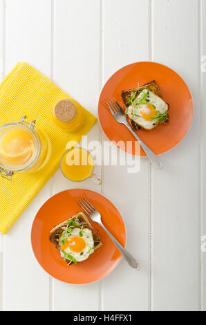 Cotta toast alla francese - Croque Madame, succo di arancia, girasole microgreens sulla parte superiore Foto Stock