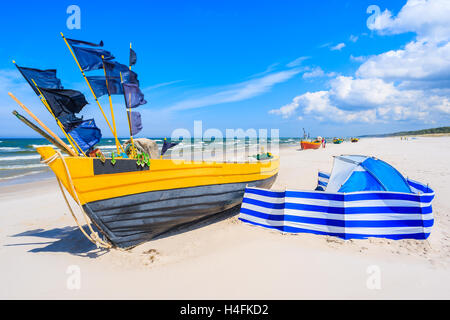 Colorate barche da pesca e giacca a vento blu con tenda di sabbia sul Mar Baltico beach, Polonia Foto Stock