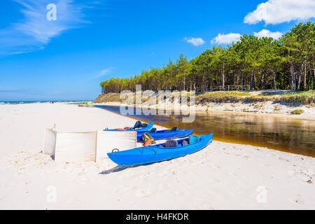 Canoe sulla spiaggia di sabbia bianca di Debki borgo dove il fiume Plasnica ha il suo estuario al Mar Baltico, Polonia Foto Stock