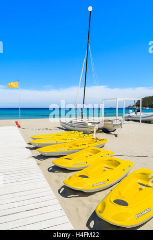 PORTO GIUNCO SPIAGGIA, SARDEGNA - 27 Maggio 2014: giallo kayak e barche catamarano sul Porto Giunco spiaggia, l'isola di Sardegna, Italia Foto Stock