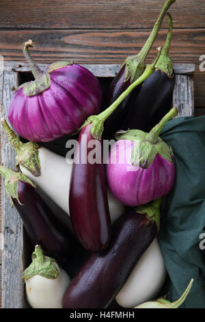 Varietà di melanzana fresca in legno rustico cassa, cibo Foto Stock