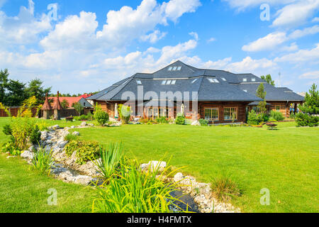 Villaggio nei pressi di Cracovia in Polonia - Agosto 9, 2014:verde giardino del ristorante tradizionale edificio sulla soleggiata giornata estiva. Stile di montagna architettura è molto popolare nel sud della Polonia. Foto Stock