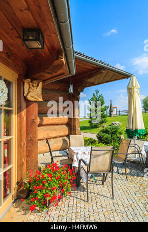 Villaggio nei pressi di Cracovia in Polonia - Agosto 9, 2014: terrazza con sedie e tavoli del ristorante tradizionale edificio sulla soleggiata giornata estiva. Stile di montagna architettura è molto popolare nel sud della Polonia. Foto Stock