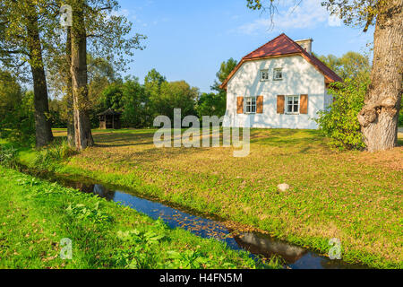 Tradizionale casa cottage e piccolo fiume nel paesaggio di campagna, Radziejowice village, Polonia Foto Stock